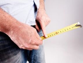 a man measures the length of the penis before enlarging it with soda